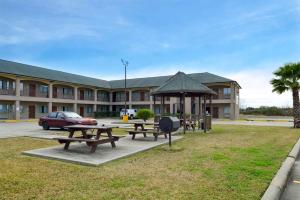 亚瑟港Econo Lodge Inn & Suites Port Arthur near Sabine Pass的一座公园,在一座建筑前设有野餐桌和凉亭