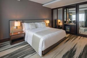 雅加达雅加达美利亚酒店&度假村的卧室配有一张白色大床和一张书桌