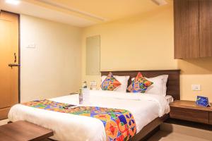 孟买FabExpress Silver Lake的一间卧室配有一张大床,提供色彩缤纷的床单和枕头