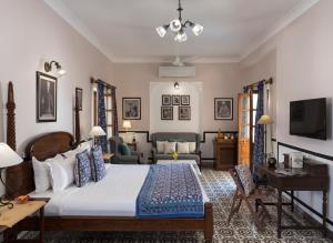 焦特布尔拉坦维拉斯酒店的一间卧室配有一张大床和一张沙发