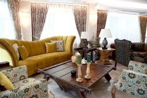 图兹拉Tuzla Garden Hotel & Spa的客厅配有黄色的沙发和桌子