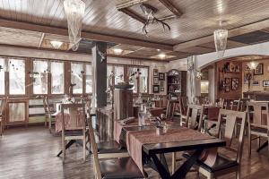萨斯费玛蒙特酒店的餐厅设有木桌、椅子和窗户。