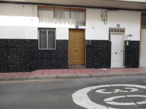 拉斯加莱塔斯A cozy flat in the heart of El Fraile的街道边有棕色门的建筑
