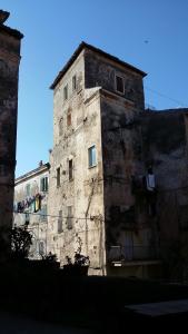 泰拉奇纳Torrione San Lorenzo I的一座古老的石头建筑,旁边设有窗户