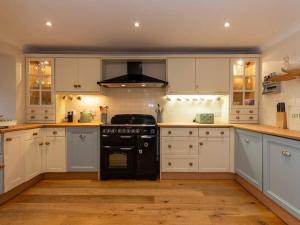 圣安德鲁斯Stunning Farm Steading - 5 Mins to St Andrews的厨房配有白色橱柜和黑炉。