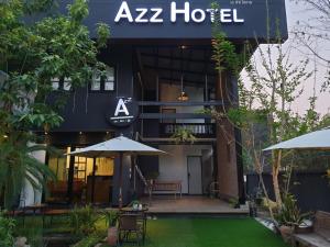 清迈Azz Hotel的斑马酒店前面设有桌子和遮阳伞
