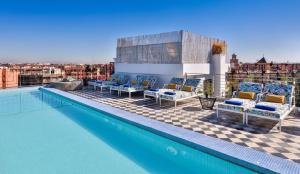 马拉喀什2希尔斯精品酒店的一个带椅子的游泳池,享有城市美景