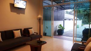 蔻立Baramate Khao Lak - SHA PLUS的带沙发和滑动玻璃门的客厅