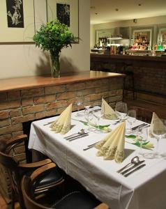 瓦赫河畔比斯特里察博特酒店的餐厅的一张桌子,上面有白色的桌布