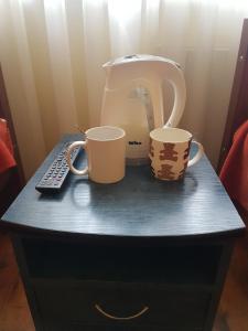陶格夫匹尔斯艾尔佛戈酒店的桌子上两个咖啡杯和一个搅拌机