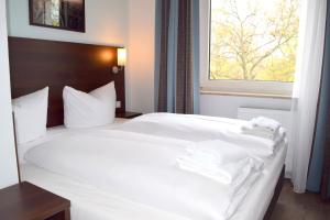 美因河畔法兰克福Trip Inn Budget Hotel Messe的卧室配有白色床和毛巾
