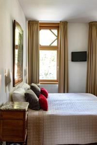 马斯特里赫特帕思提斯酒店的卧室配有带枕头的床铺和窗户。