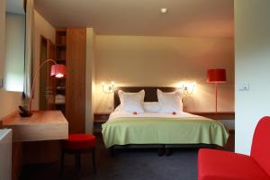 阿尔泽特河畔埃施七号酒店的酒店客房,配有一张床和一张红色椅子