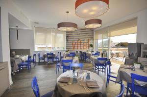 卡尔切拉尼卡阿拉戈能源酒店的一间配备有桌子和蓝色椅子的用餐室