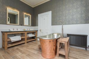 安布尔塞德The Lake House, Wansfell Holme, Windermere的一间带铜浴缸和两个盥洗盆的浴室