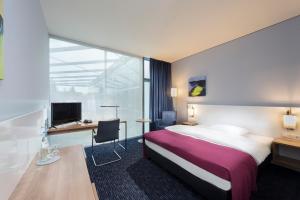柏林Seminaris CampusHotel Berlin的配有一张床和一张书桌的酒店客房