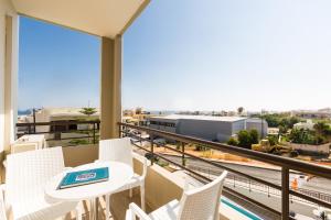 罗希姆诺爱提娜公寓式酒店的设有一个配有桌椅并享有美景的阳台。