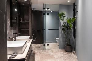 雅典派瑞安斯酒店的一间带两个盥洗盆、淋浴和卫生间的浴室