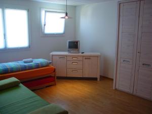 埃申茨拉本酒店的一间卧室配有一张床,梳妆台上配有电视