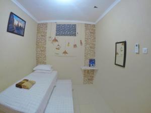 日惹恩达利艾安格维耶旅馆的小房间设有两张床和一面墙