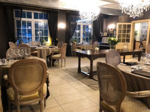 马尔梅迪Hostellerie de la Chapelle的用餐室配有桌椅和吊灯。