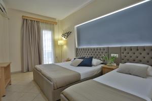 乐托卡亚Irida Apartments的酒店客房设有两张床和大窗户。