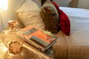 马斯特里赫特帕思提斯酒店的一张玻璃桌,上面有书,床上有一瓶