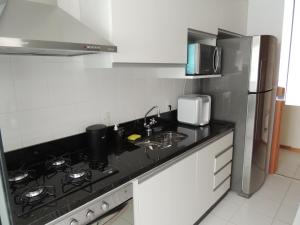 巴西利亚Apartamento 2 quartos Living Park Sul的厨房配有炉灶、水槽和冰箱。