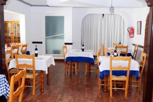 莫哈卡尔Hospedería Ancladero的餐厅设有2张带蓝白桌布的桌子