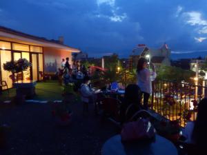 卡赞勒克Семеен Хотел РОЗА的一群人晚上坐在阳台上
