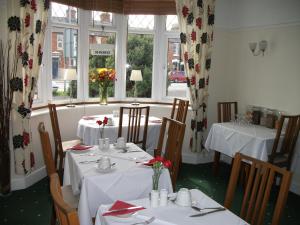 埃文河畔斯特拉特福Green Haven Guest House的一间用餐室,配有2张带白色桌布的桌子