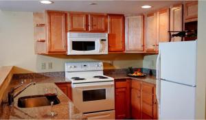 拉德洛城堡山点度假村&Spa酒店的厨房配有木制橱柜和白色冰箱。