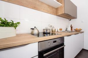 奥库格哥恩基Apartment One的厨房设有白色的墙壁和木制台面