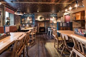 锡厄姆The Seaton Lane Inn - The Inn Collection Group的餐厅设有木桌、椅子和壁炉