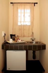奥奇瓦龙戈卡达萨旅馆的带水槽的厨房台面和窗户