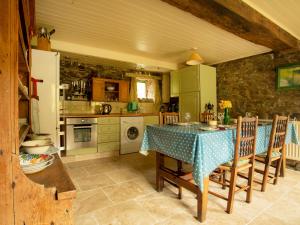 TrefeglwysDolgenau Cottages的厨房配有桌椅和冰箱。