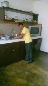 瓦哈卡市La casa del nenufar的站在厨房水槽上的人