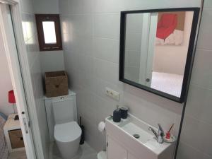 奥亚A Guaira, fantástico apartamento al borde del mar的一间带卫生间、水槽和镜子的浴室