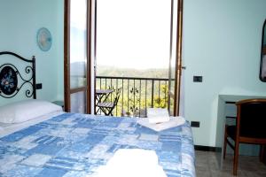 皮尼奥内Antiche Terre Hotel & Relax的一间卧室设有一张床和一个阳台