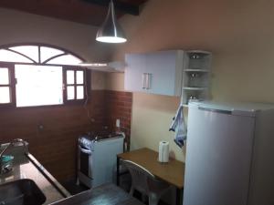 特雷索波利斯Suíte com vista da Serra的一间带桌子和冰箱的小厨房