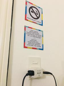 布宜诺斯艾利斯LOPEZ Hostel & Suites的墙上的标志,有禁止吸烟的标志