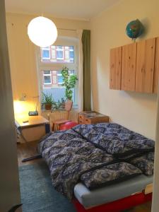 吕讷堡Feldstraße 10的一间卧室配有一张床、一张书桌和一个窗户。