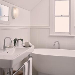 尼尔森湾安克雷奇斯蒂芬斯港酒店的白色的浴室设有浴缸和水槽。