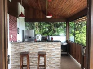 尼泰罗伊Itaipu Beach House的厨房配有带2把凳子的柜台
