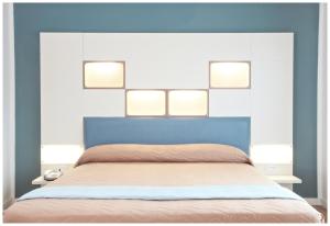 利多迪耶索罗丹特酒店的一间卧室,床上方有四盏灯