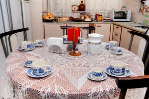 迪亚曼蒂纳Pousada Casa da Cintia的厨房里摆放着茶杯和碟子的桌子