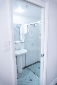悉尼悉尼南部大酒店的白色的浴室设有水槽和淋浴。