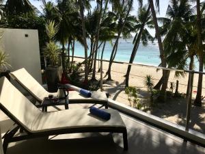 长滩岛日落海滩一室公寓式酒店的一个带椅子的阳台,享有海滩美景