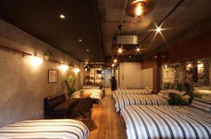 名古屋Guest House Re-worth Yabacho1 1F的一间设有四张床和一张桌子及椅子的房间