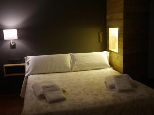 Aren多门客酒店的一间卧室配有一张床,上面有两条毛巾